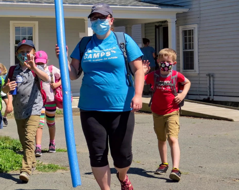 a person wearing a mask and a mask walking with kids