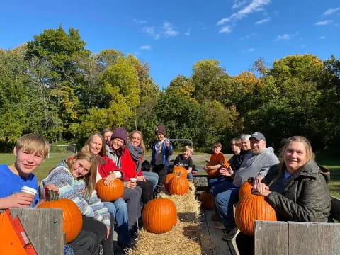 a group of people sitting on pumpkins in a field