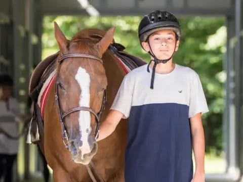 a boy with a helmet and a horse