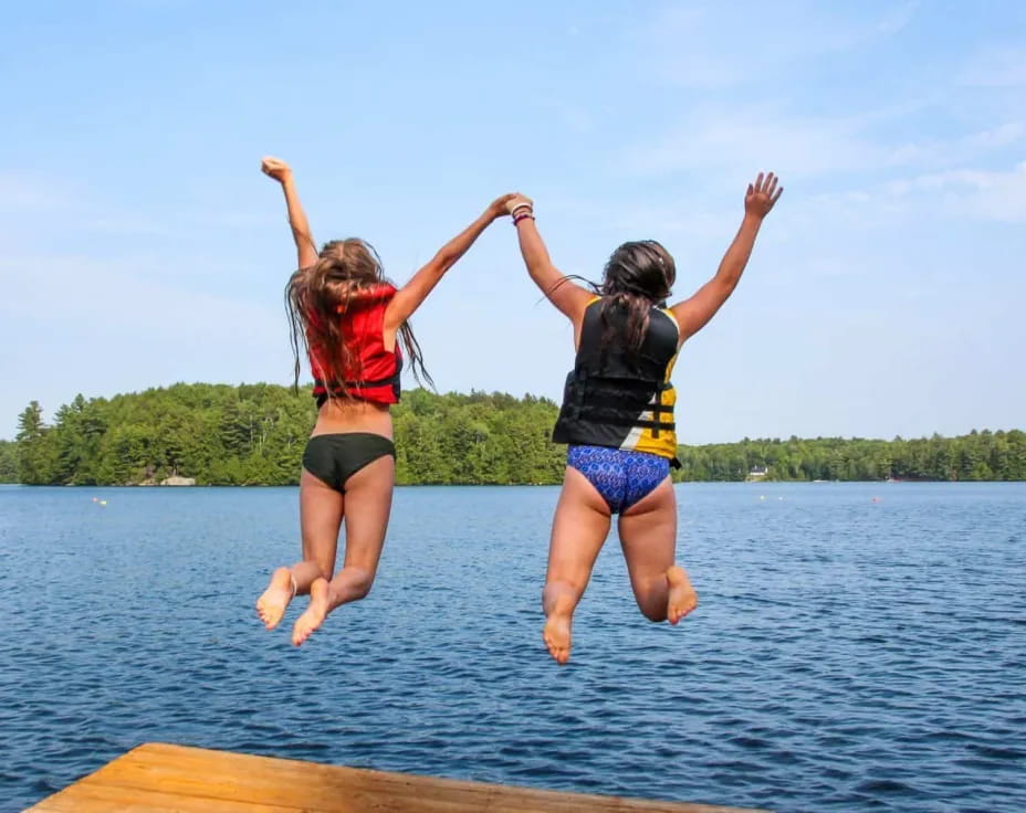 two women jumping into water