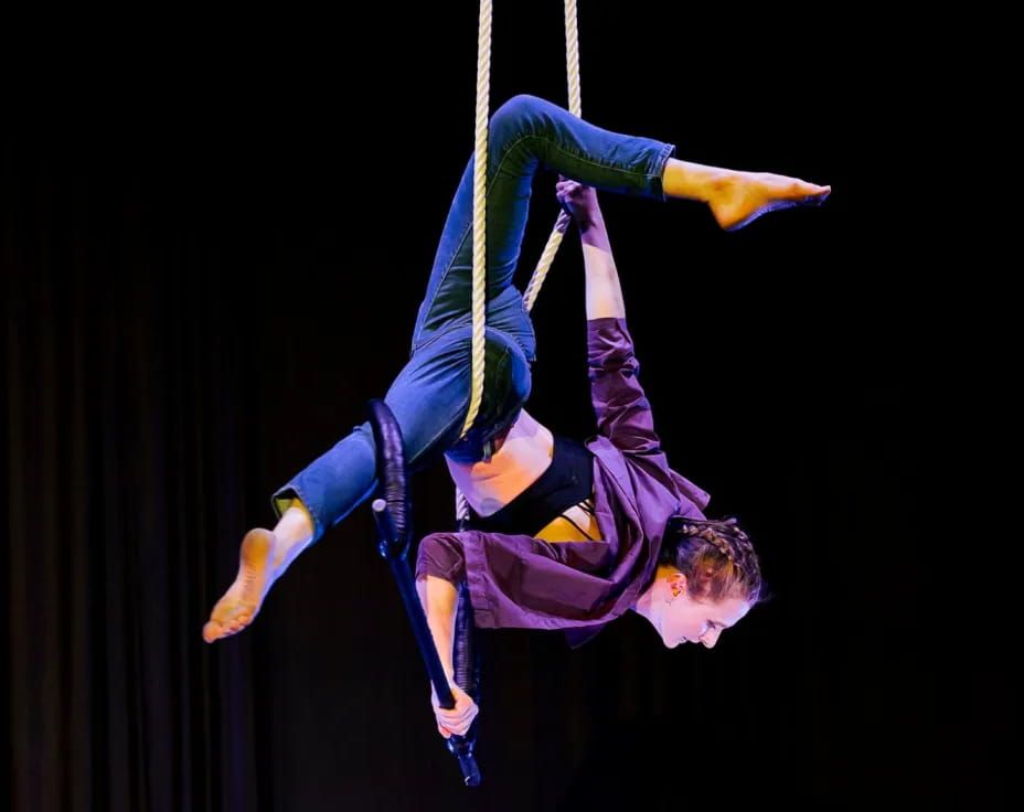 a person from a rope with Circus Juventas in the background