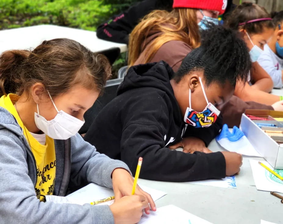 a group of children writing on paper