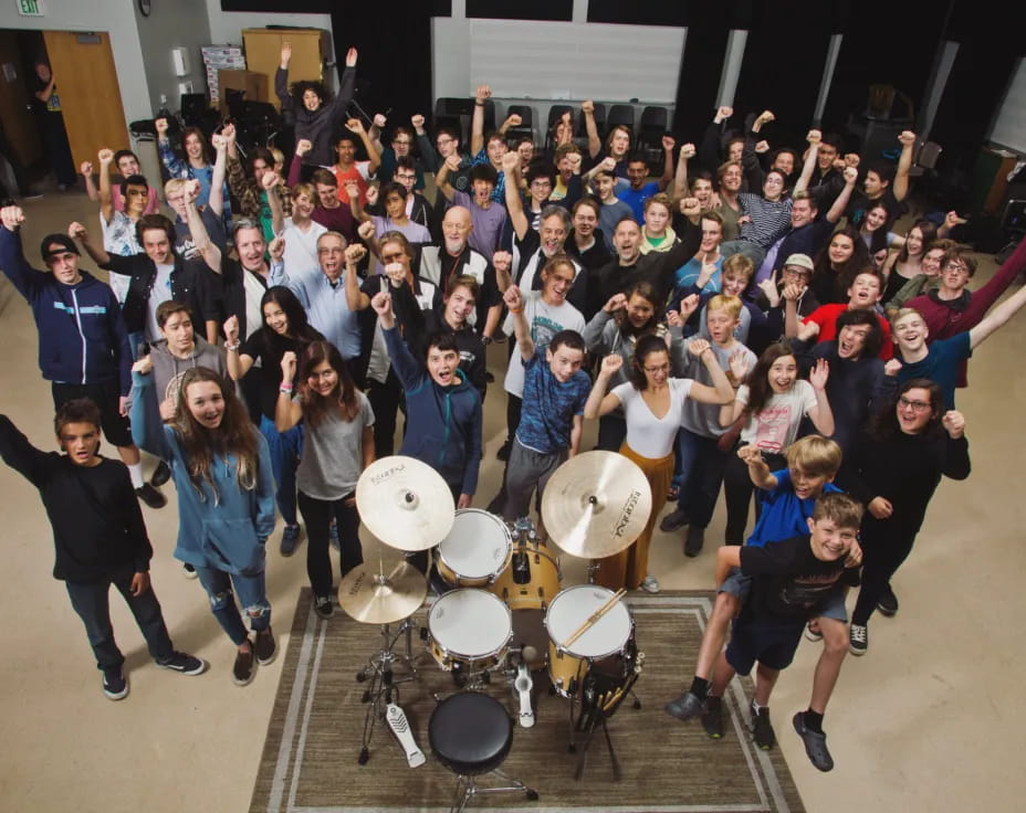 a group of people posing for a photo with drums