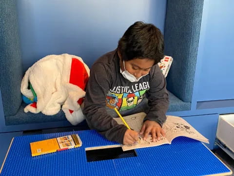 a boy writing on a book