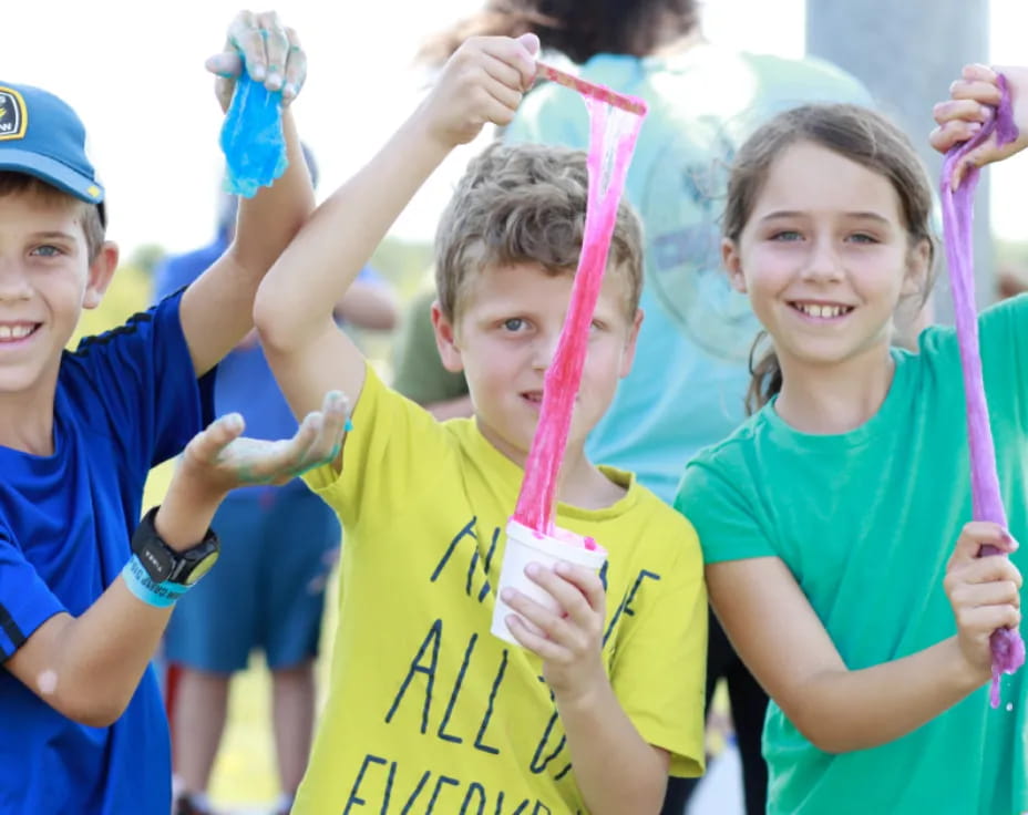 a group of children holding up blue and yellow objects