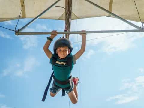 a young girl in a harness on a zip line