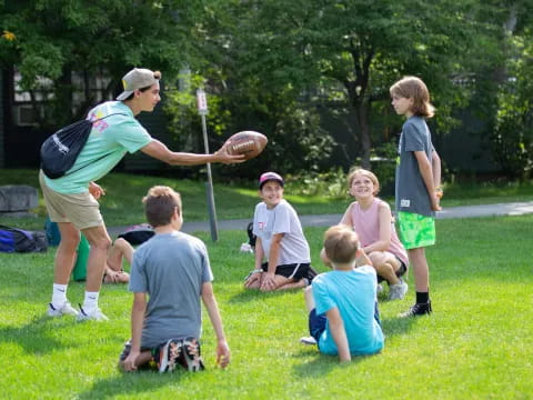 a person throwing a ball to kids
