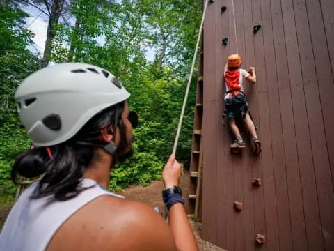 a person wearing a helmet and a boy on a ladder