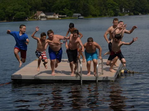 a group of boys jumping into the water