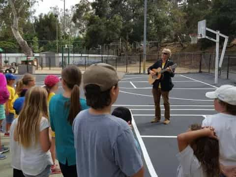 a person playing a guitar in front of a crowd of people