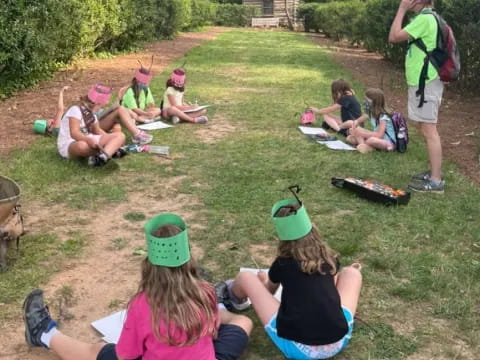 a group of people sitting on the grass