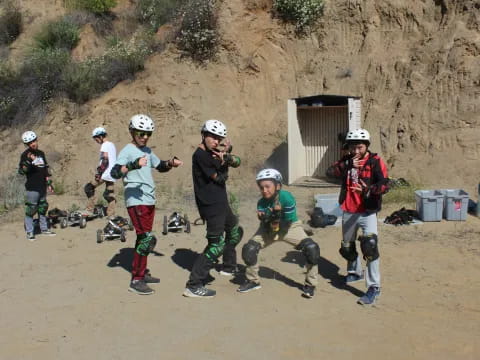 a group of people wearing helmets and running on a dirt road