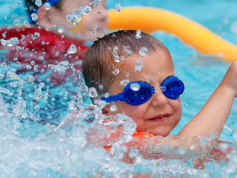 a boy wearing goggles and swimming