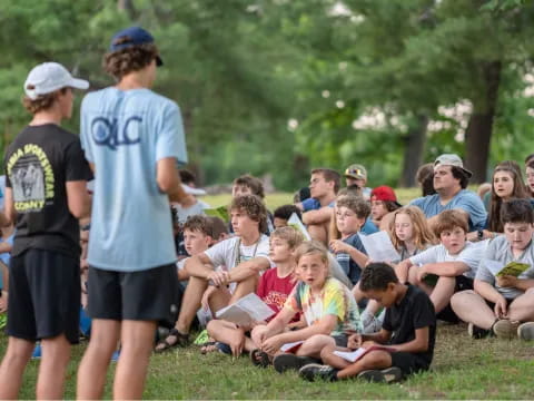 a group of people sitting on the grass