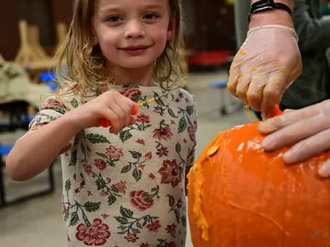 a girl holding a pumpkin