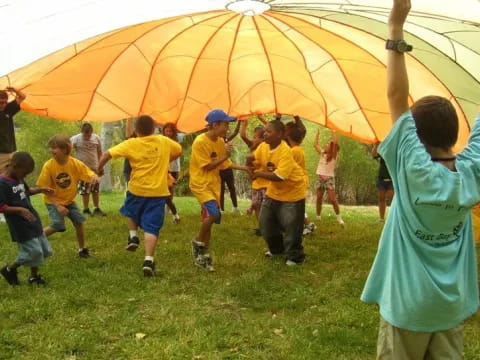 a group of kids playing with an umbrella