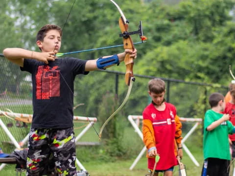 a group of kids playing with a bow and arrow