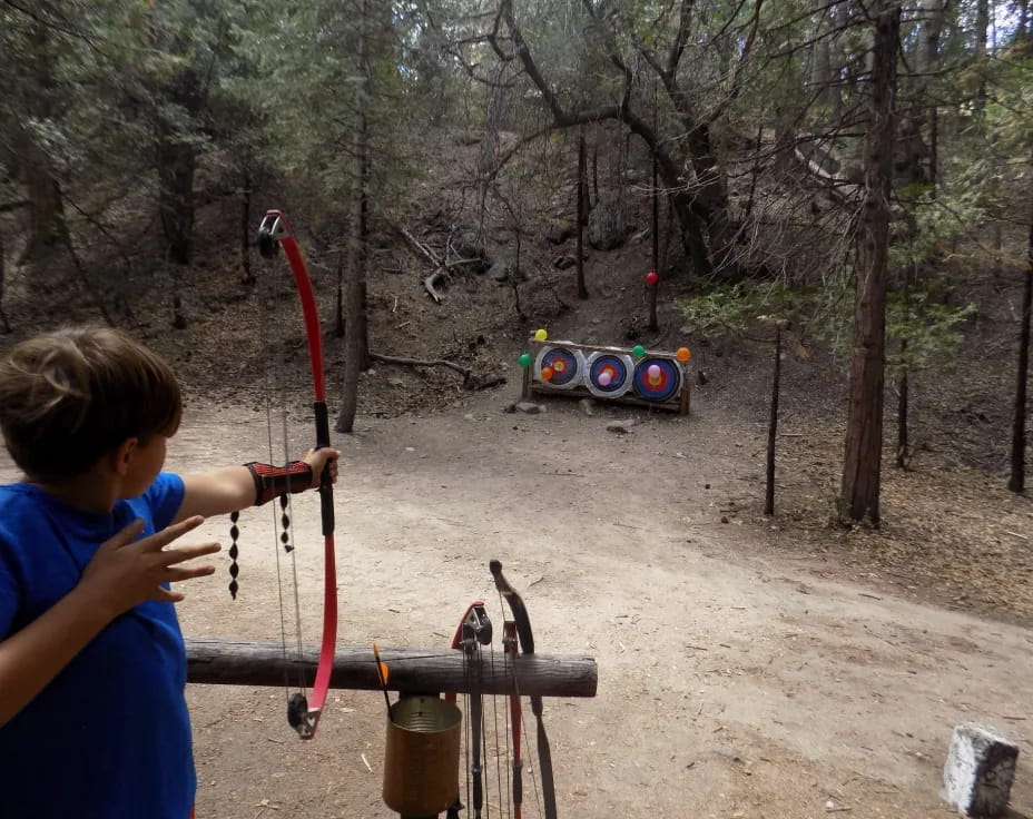 a boy shooting a bow and arrow