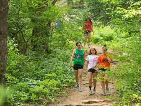 a group of people running on a trail in the woods