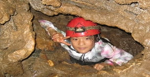 a baby in a hat in a hole in the ground