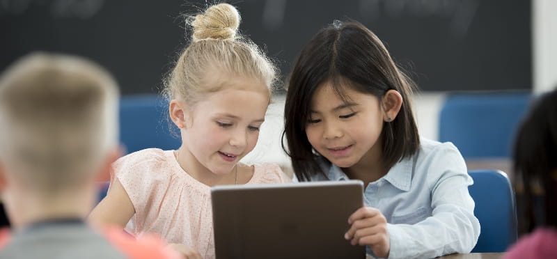 a few children looking at a laptop