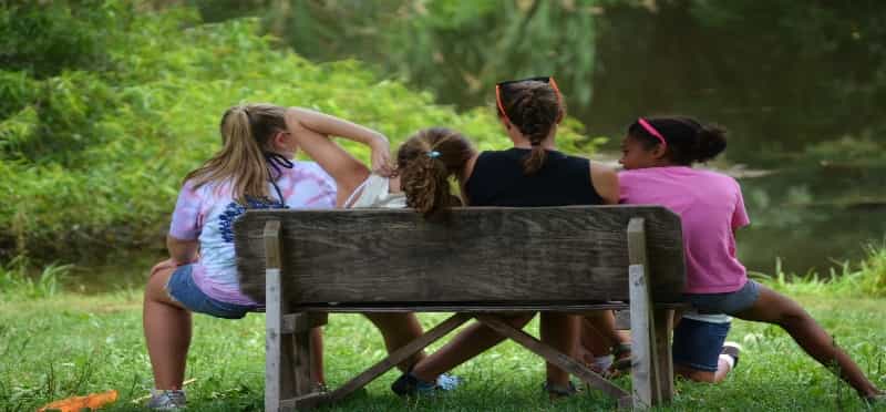 a group of girls sitting on a bench