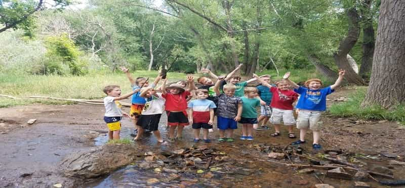 a group of kids jumping in a river