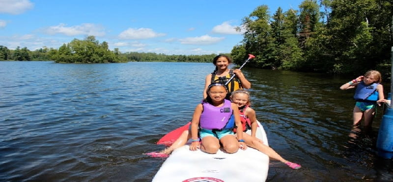 a group of kids on a raft in a lake