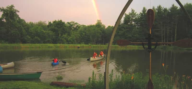 a group of people in a row boat on a lake