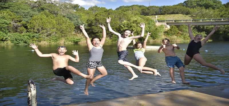 a group of people jumping into a body of water
