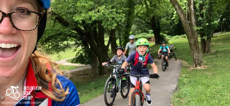 a group of people riding bikes on a path in a park