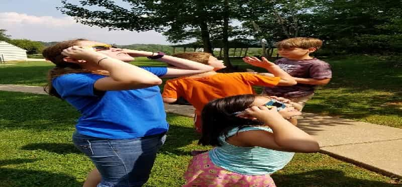 a group of people stretching in a grassy area