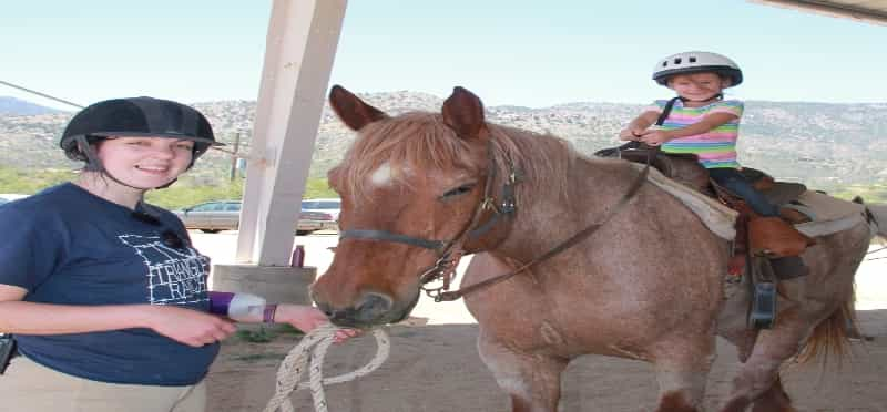 a person and a child riding a horse