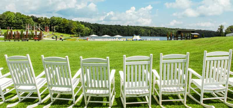 a row of white chairs on a lawn