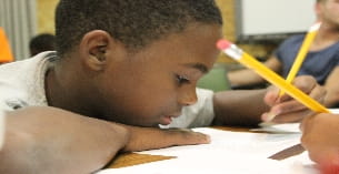 a young boy writing on a paper