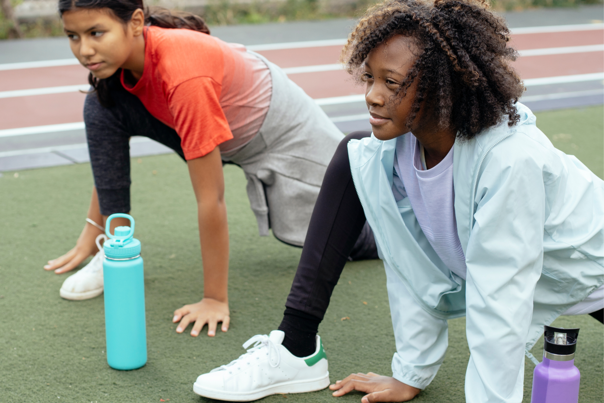 a woman and a man doing push ups on a grass field