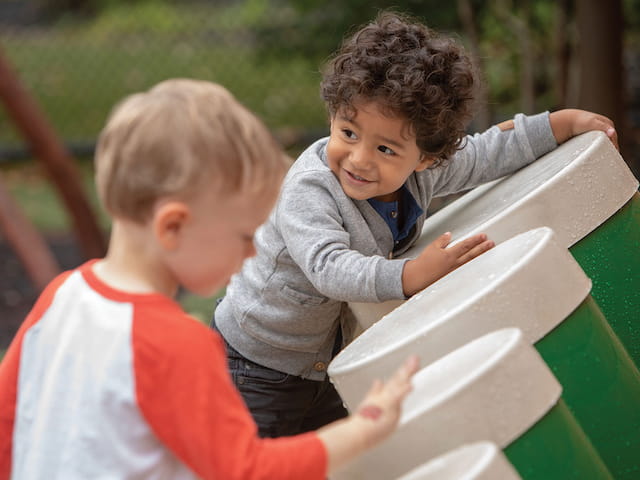 a couple of kids playing with a green table