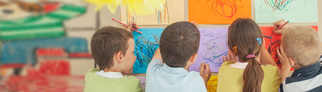 a group of children drawing on a white board