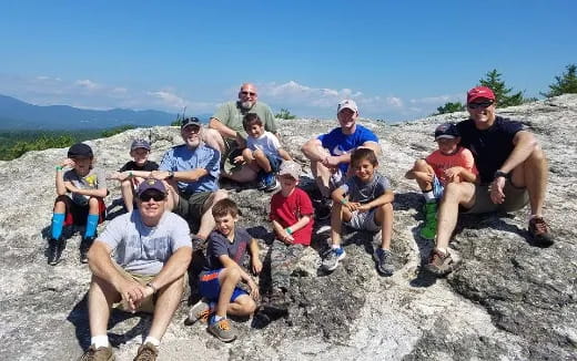 a group of people sitting on a rock