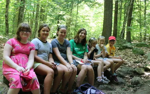 a group of people sitting on rocks in the woods