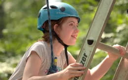 a person wearing a helmet and climbing a ladder