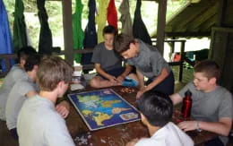 a group of people sitting around a table playing a board game