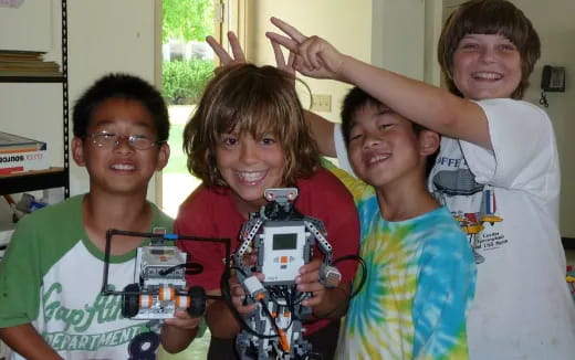 a group of kids holding a robot