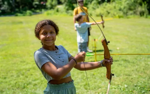 a young girl holding a bow and arrow