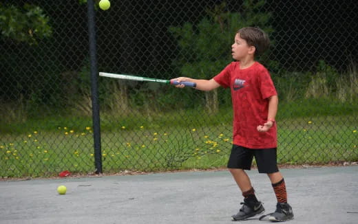 a boy hitting a ball with a baseball bat