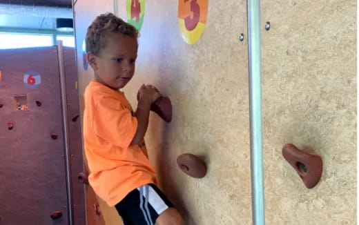 a boy climbing a wall