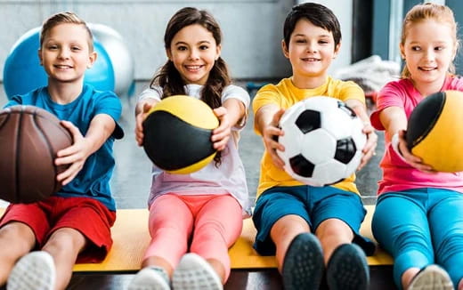 a group of children holding a football ball