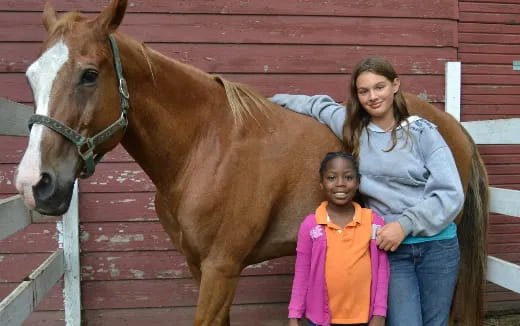 a person and a girl posing with a horse