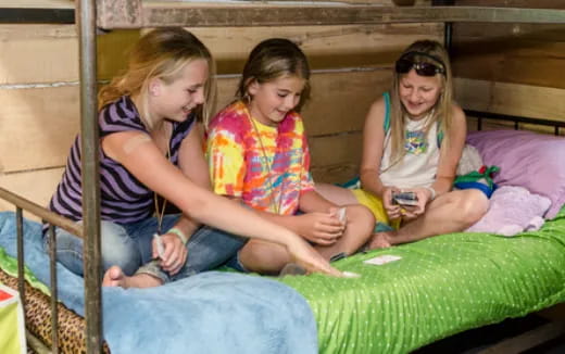 a group of women sitting on a bed