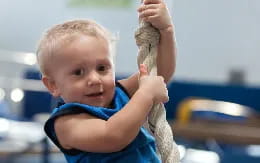 a baby holding a rope